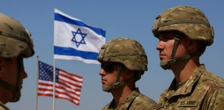 🇺🇸🇮🇱 Estados Unidos enviará 200 soldados a Israel para monitorear el alto al fuego en Gaza Soldados estadounidenses junto a las banderas de Estados Unidos e Israel en una zona desértica, simbolizando el apoyo militar de Washington al alto al fuego en Gaza.
