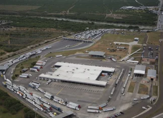 Revisión del T-MEC 2026: qué pasó, qué pide Estados Unidos y qué significa para México Vista aerea de un cruce fronterizo comercial entre Mexico y Estados Unidos