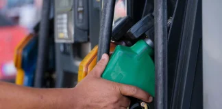 Precio de la gasolina hoy en México: el tope de 24 pesos y las ciudades donde no se cumple Mano sosteniendo la pistola despachadora de gasolina en una estación de servicio