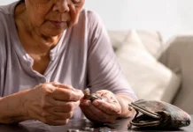 Bukele dice que los gobiernos se endeudan y luego cobran más impuestos: lo que muestran las cuentas de El Salvador Persona mayor contando monedas sobre una mesa