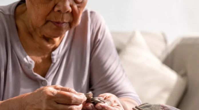 Bukele dice que los gobiernos se endeudan y luego cobran más impuestos: lo que muestran las cuentas de El Salvador Persona mayor contando monedas sobre una mesa