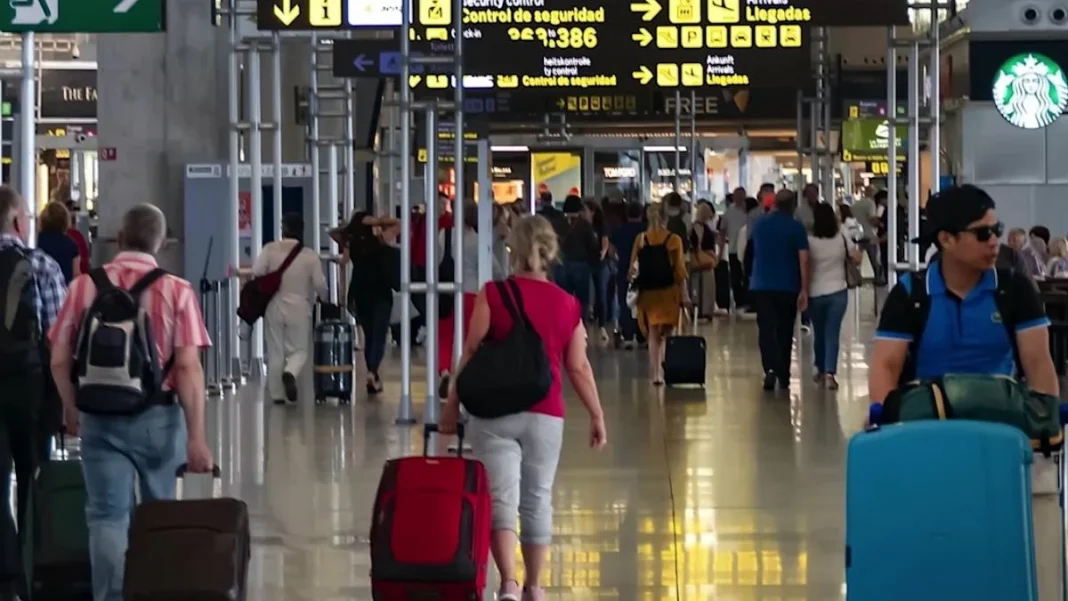 Turistas con maletas en la terminal de un aeropuerto Turistas con maletas en la terminal de un aeropuerto